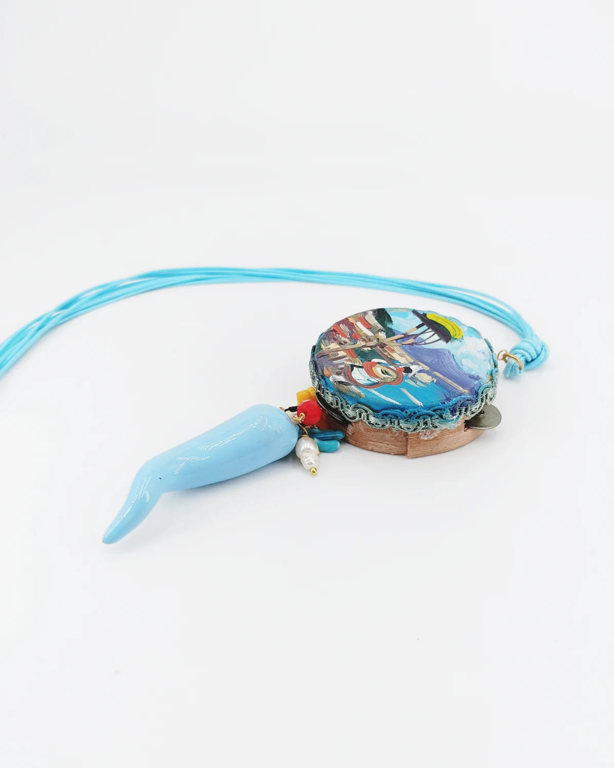 Collana con tamburello Pulcinella e Vesuvio appoggiata