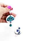 Orecchini di carta Inside out invidia e noia su mano