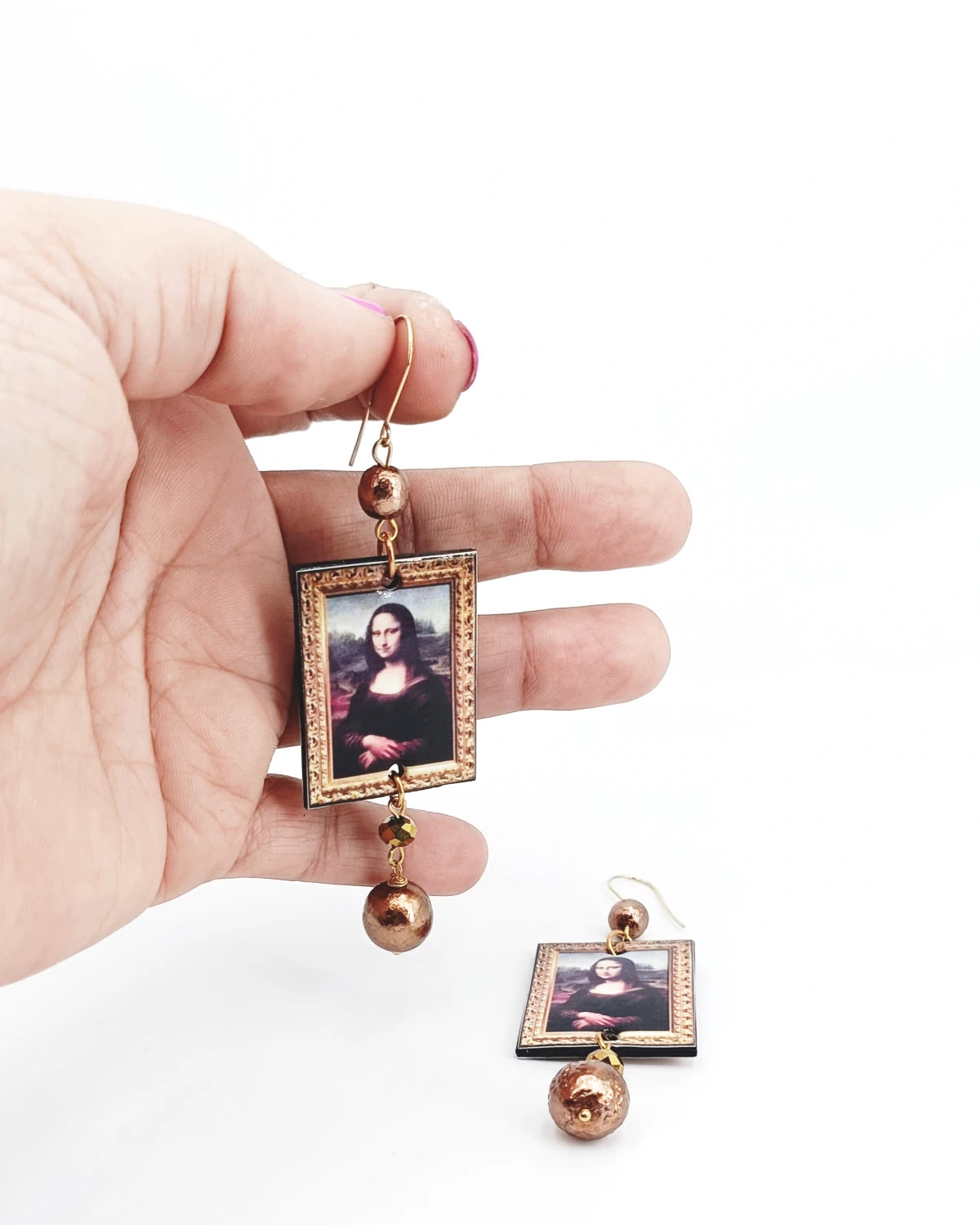 Orecchini di carta La Gioconda su mani