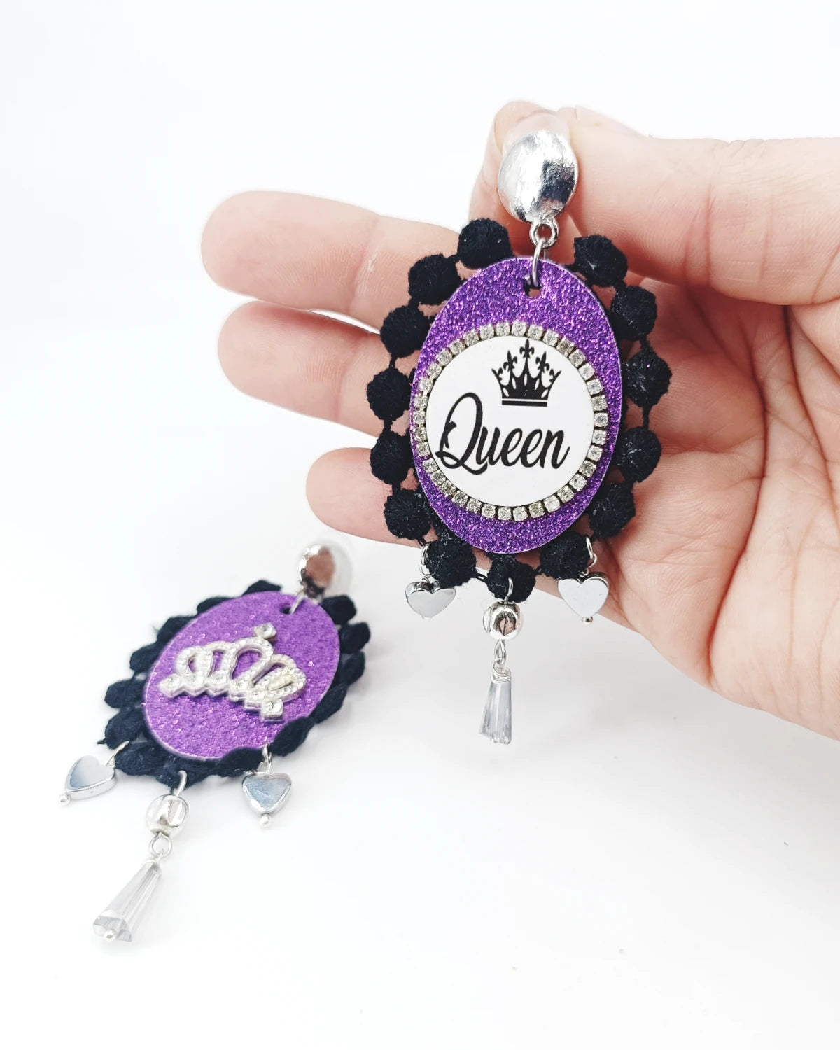 Orecchini di carta Queen su mano