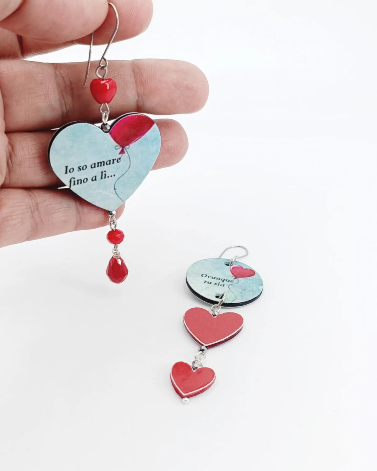 Orecchini di carta Amo fino a lì su mano