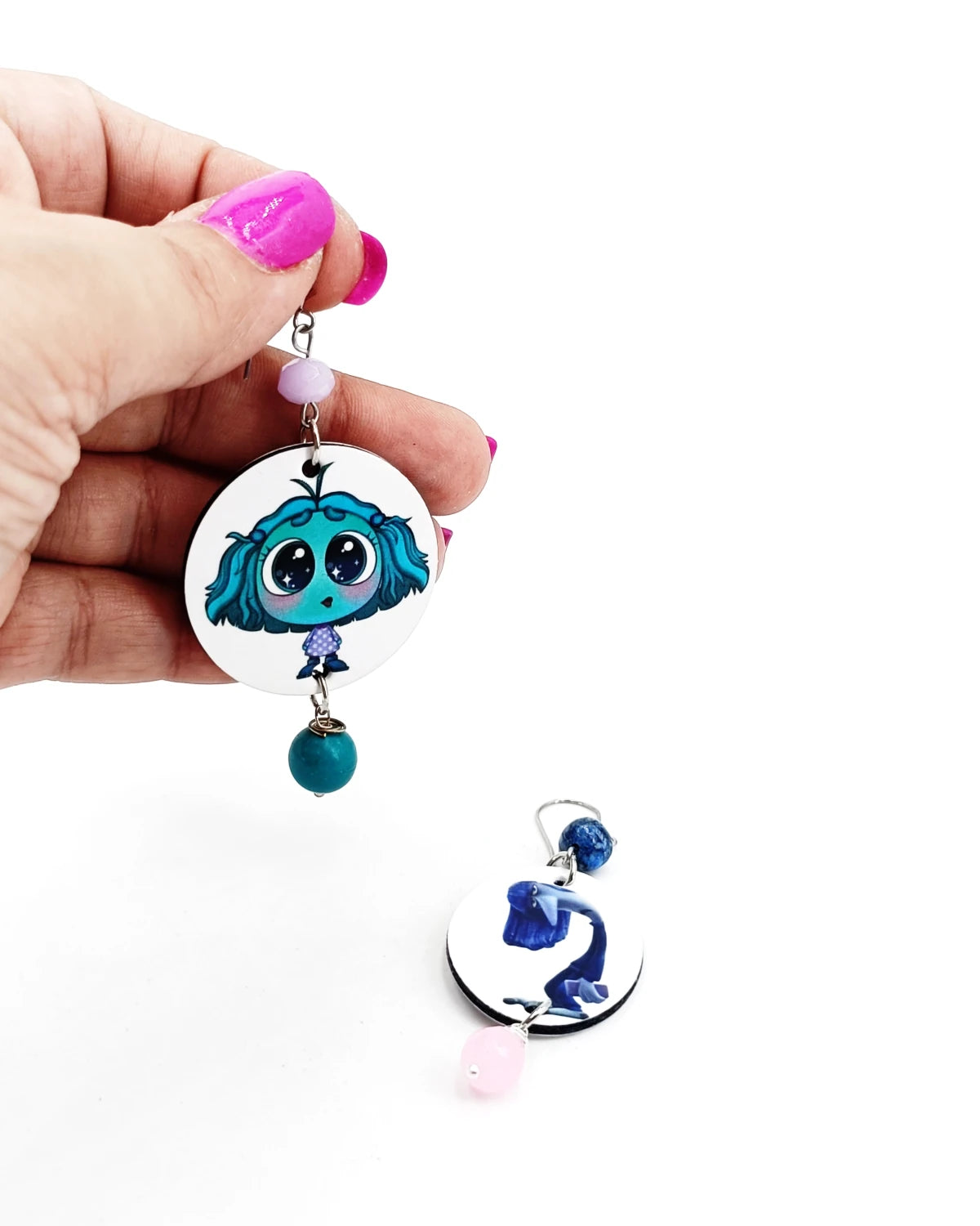 Orecchini di carta Inside out invidia e noia su mano